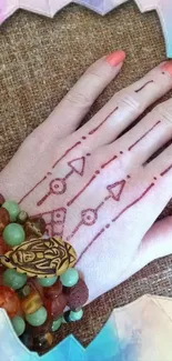 Hand with henna design and colorful bracelets.