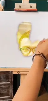 Hand painting a face on canvas with vibrant colors.