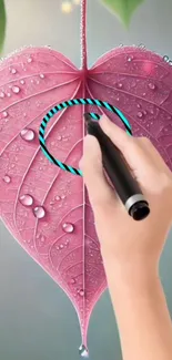 A hand drawing on a pink leaf with water droplets on it.