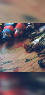 Vibrant paintbrushes on a wooden textured surface.