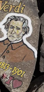 Painted rock tribute to Giuseppe Verdi vividly displayed on a rocky surface.