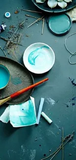 Turquoise artistic setup with paint and brushes.