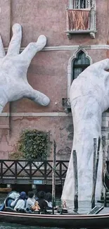 Venice canal view with large sculpted hands.