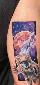 Tattoo of an astronaut with a space scene featuring a planet and nebula on an arm.