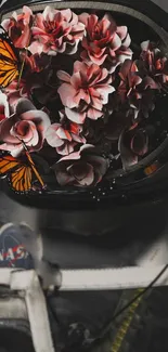 Astronaut helmet filled with pink flowers and butterflies.