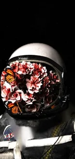 Astronaut helmet filled with flowers and butterflies on black background.