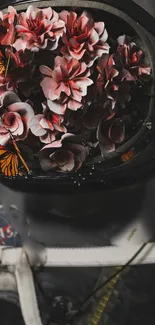 Astronaut helmet filled with flowers and butterflies on a dark background.