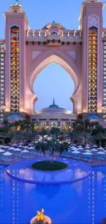 Atlantis Hotel at sunset with blue-lit pool reflecting lights.