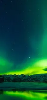 Aurora Borealis over mountains reflecting in a calm lake under a starry sky.