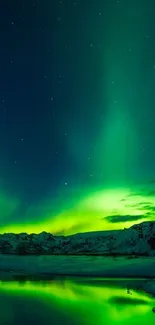 Aurora Borealis over a snowy mountainous landscape with a reflective lake.