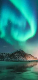 Aurora Borealis over snowy mountains and lake.