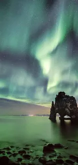 Mesmerizing Northern Lights above calm sea and rocky landscape.