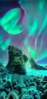 Aurora borealis over rocky seashore with teal and green lights.