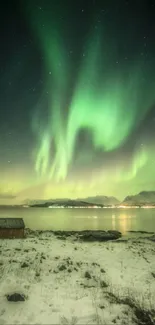 Northern Lights with snowy landscape and a cabin under a green aurora glow.