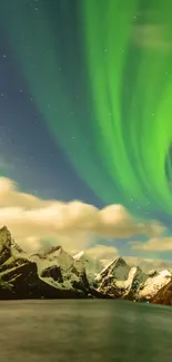 Aurora borealis lights up snow-capped mountains under a starry sky.