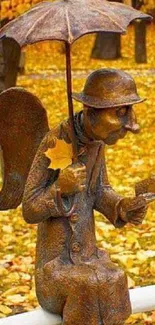 Statue of an angel with an umbrella surrounded by autumn leaves.