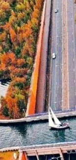 Aerial view of a bridge over a waterway in autumn, with vibrant foliage.