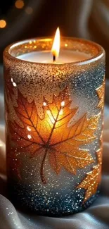 Autumn candle with glowing golden leaves design.