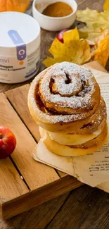 Cinnamon bun with apple and autumn decor on a wooden board.