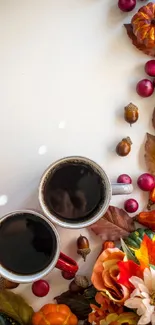 Two coffee cups on a table surrounded by autumnal decorations.