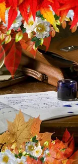 Autumn-themed wallpaper with leaves, flowers, and a vintage desk.