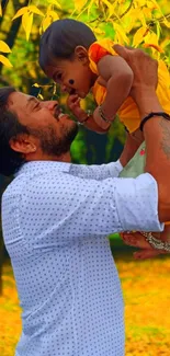 Father lifts child in autumn forest scene.