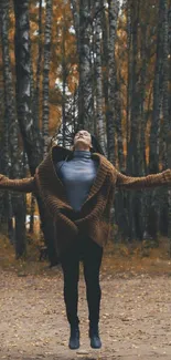 Person standing in an autumn forest with orange foliage and trees.