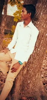 Person in serene autumn forest leaning against tree.