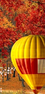 Vibrant hot air balloon amidst autumn foliage.