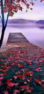 Autumn leaves scatter on a wooden dock by a misty lake, reflecting season's serenity.