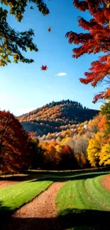 A vibrant autumn mountain landscape with colorful leaves and clear blue sky.