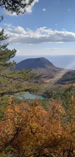 Autumn landscape with mountain and colorful foliage under clear skies.