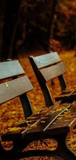 Autumn park benches with fallen leaves on a vibrant fall background.