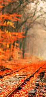 Scenic autumn railway path with vibrant orange leaves.