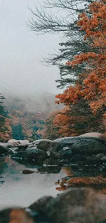 Autumn scene with river reflection and orange foliage.