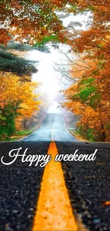 Autumn road with vibrant leaves and misty horizon, text 'Happy weekend'. 