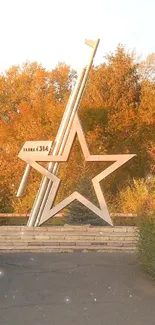 Autumn pathway with star sculpture amid vibrant orange foliage.