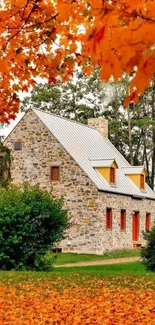 Stone cottage surrounded by orange autumn leaves.