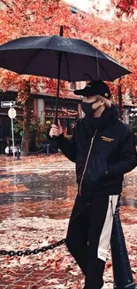 Person with umbrella walking through autumn leaves in city.