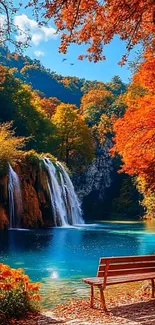 Vibrant autumn scene with waterfall and bench.