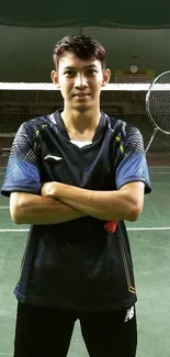 Badminton player standing on indoor court with a racket.