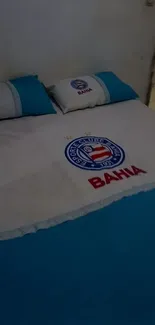 Bahia-themed bed with logo and blue pillows.