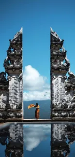 Balinese temple with clear sky and reflection on water.