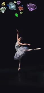 Ballet dancer in pointe with colorful gemstones above on black background.