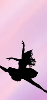 Silhouette of ballet dancer leaping on pastel pink and purple background.