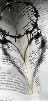 A barbed crown casting a heart shadow on an open book page.