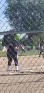 Exciting baseball game action captured behind fence with focus on batter.