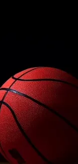 Vibrant basketball on dark background wallpaper for mobile