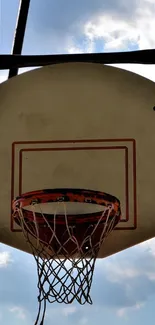 Basketball hoop with blue sky and clouds in the background.