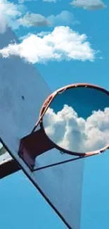 Basketball hoop with cloud reflection against blue sky.